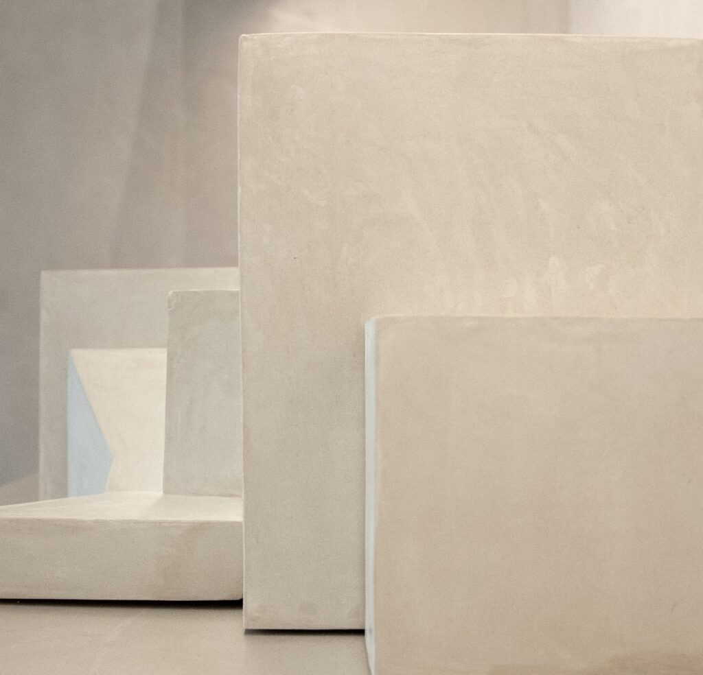 Carious sized concrete blocks in a beige color sit in front of each other.