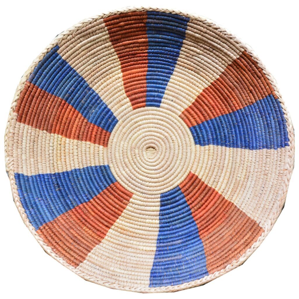 A circular rug in white, blue, and red slices sits on a white background.