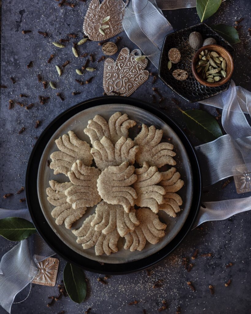 A plate full of biscochitos with chai seasoning on top in the shape of yucca flowers.