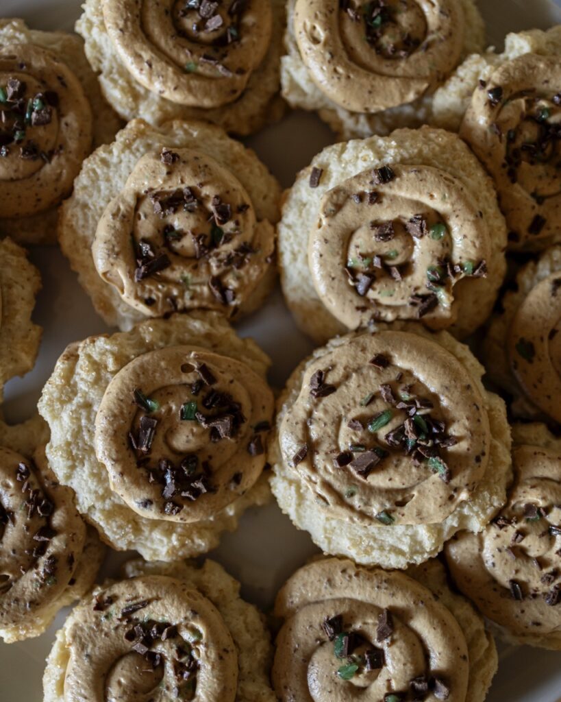 A stack of peppermint crisp sugar cookies with pieces of chocolate on top.