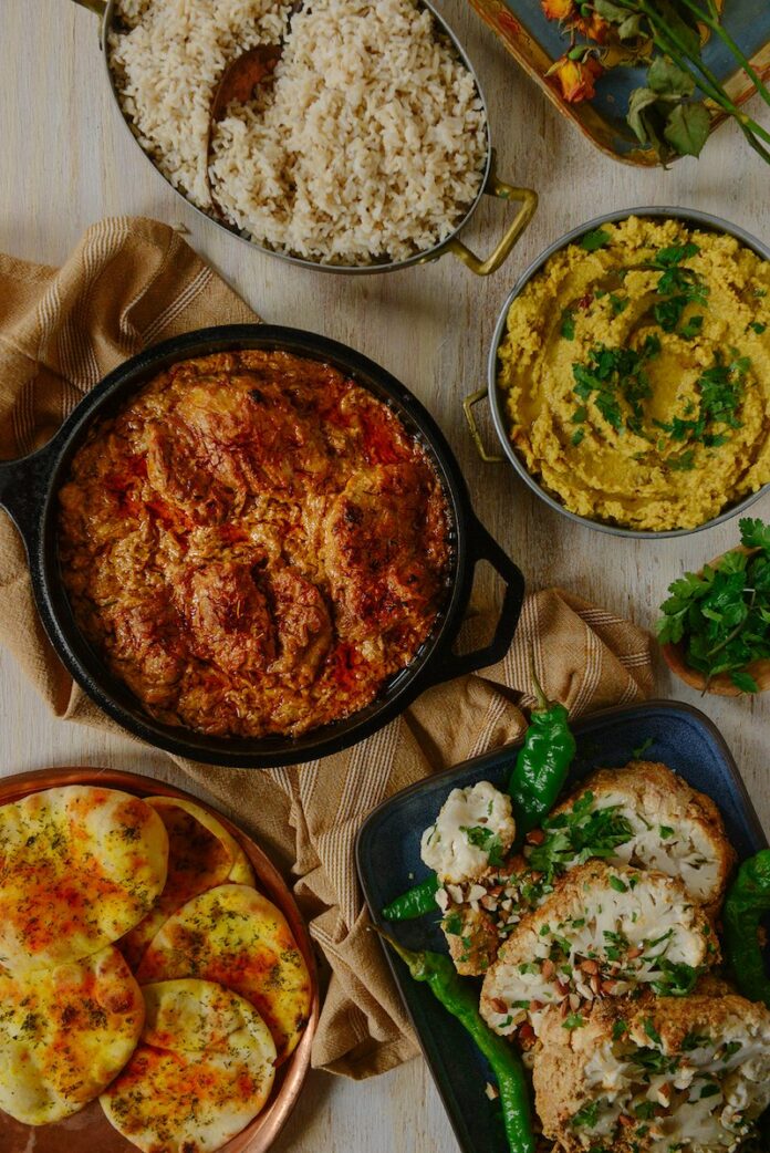 A skillet of Chicken Chaap beside slices of bread from Asma.