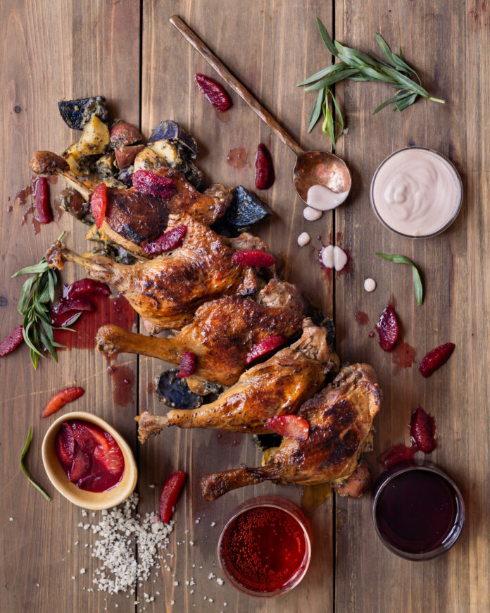 Duck legs arranged in a line with various sauces