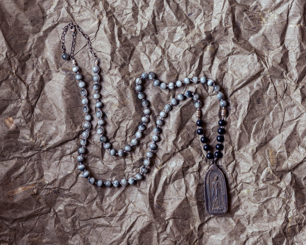 A beaded necklace that looks like an antique dog tag