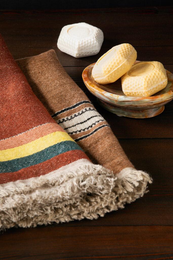 A soap dish with three pieces of soap next to a printed towel