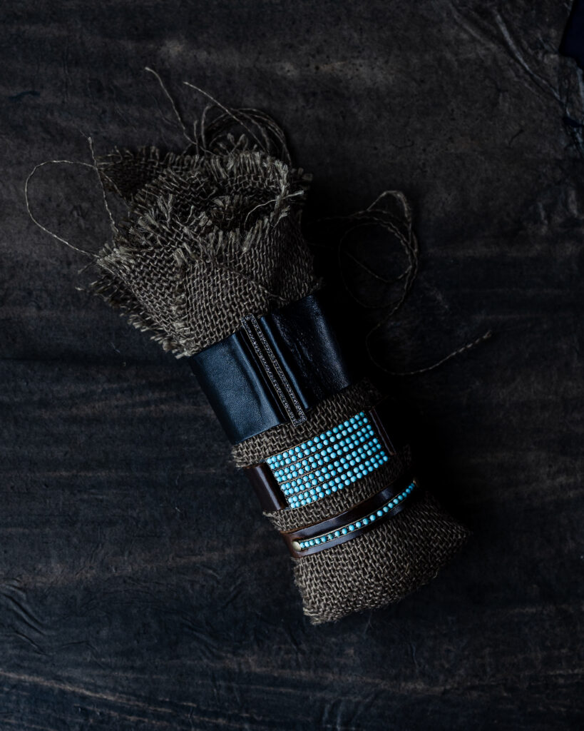 cuffs in leather and turquoise around a black cloth. jewelry gifts for women