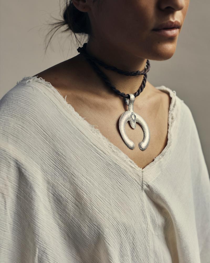 Made from recycled sterling silver, this stamped and tufa-cast naja can be worn long or as a choker. 