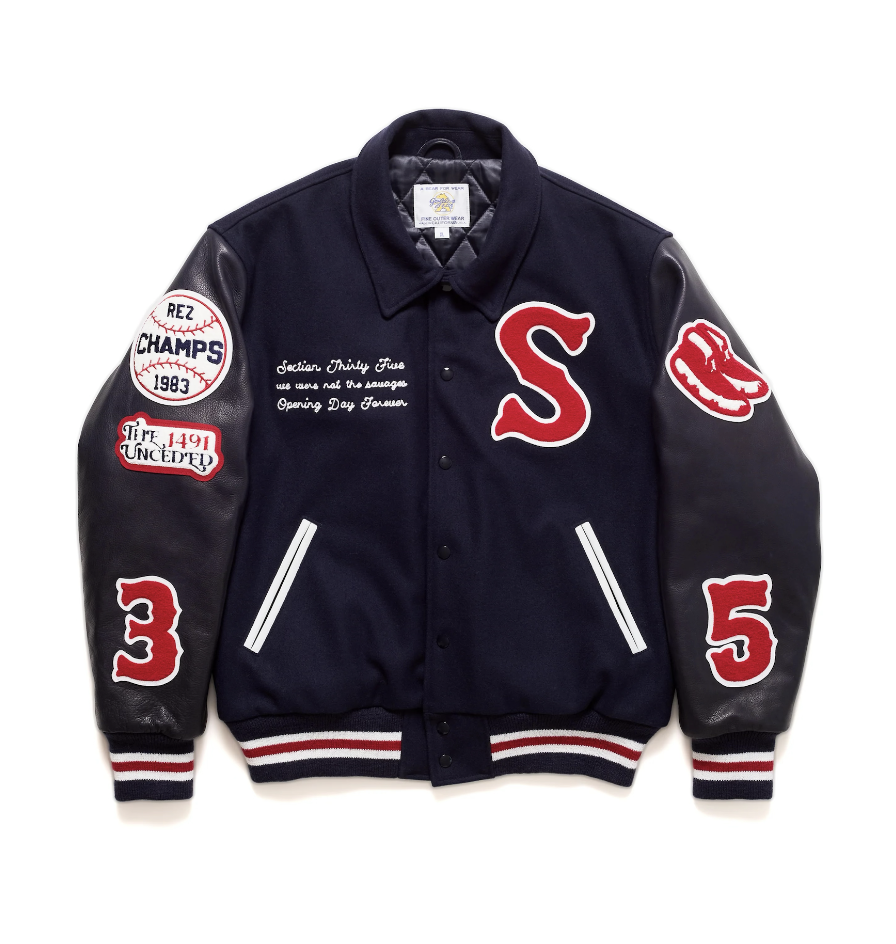 A letterman jacket in a navy blue with a big red "S" on the chest and 3 and 5 on the sleeves.