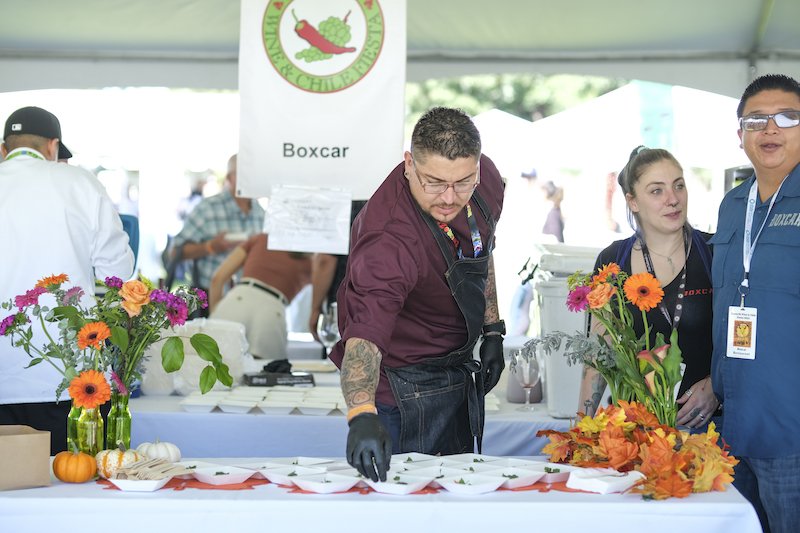 A chef places samples down on a white table.