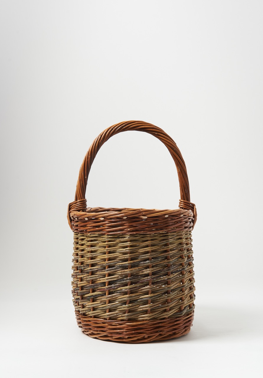 A brown simple tall basket sits against a white background for summer products.