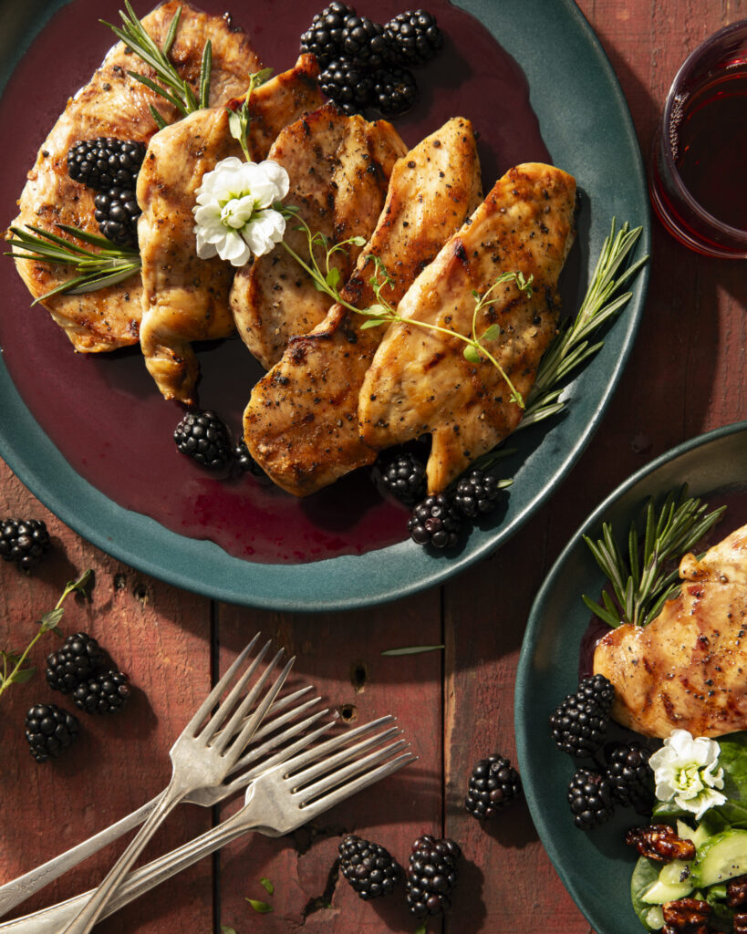 A blackberry chicken recipe with sprigs of rosemary for garnish