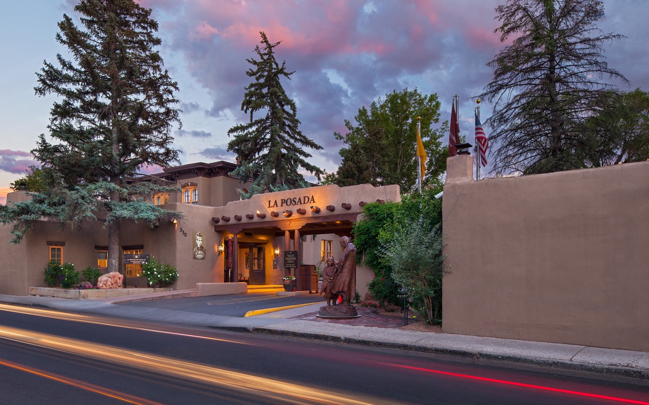 The outside of La Posada is surrounded by small trees and lights.