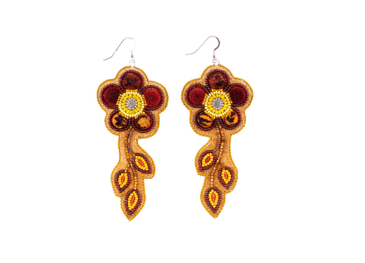 Two red beaded flower earrings on a white backgrounnd