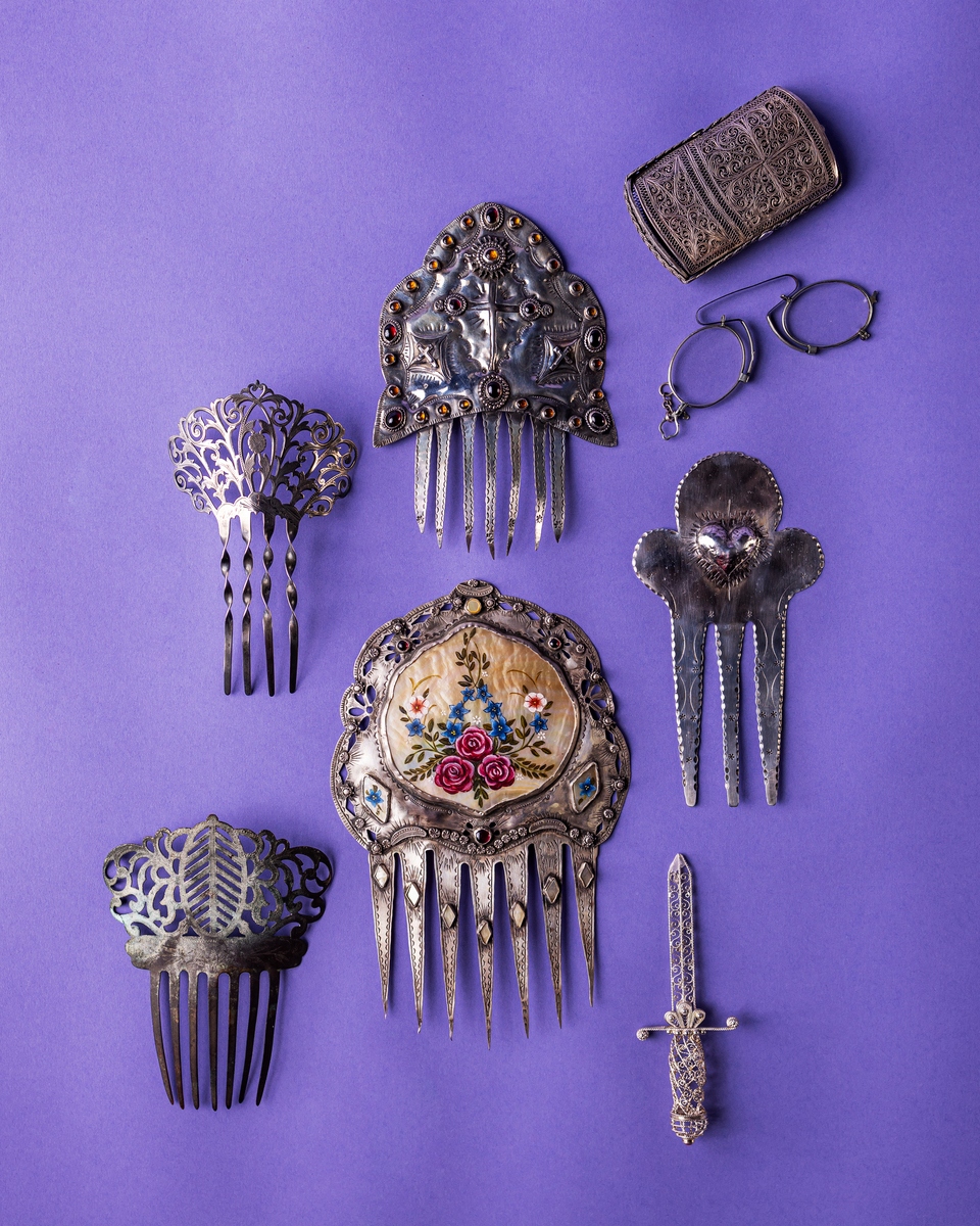 Collection of ornate vintage hair combs and accessories on a purple background.