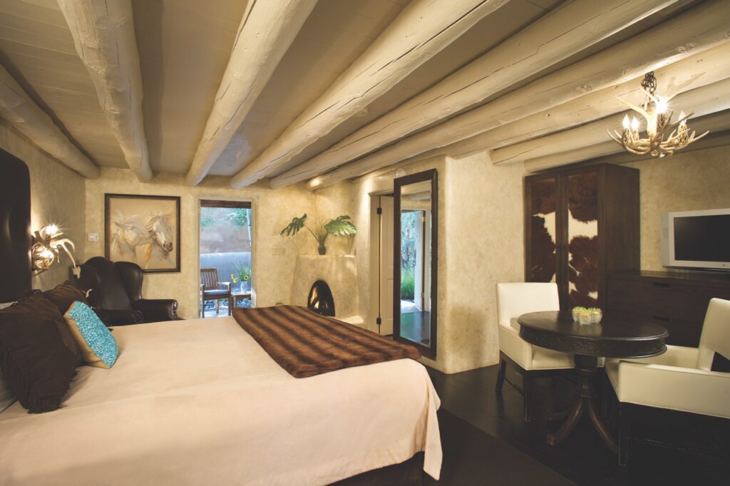 A Winter Staycation at El Monte Sagrado A bedroom with a large white bed, patterned ceilings, and plenty of open space.