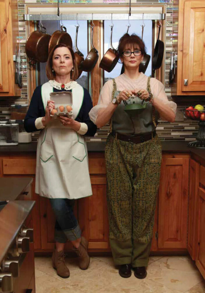 Lisa Lucas and DeBrianna Mansini stand in their kitchen, cooking comfort food but looking badass