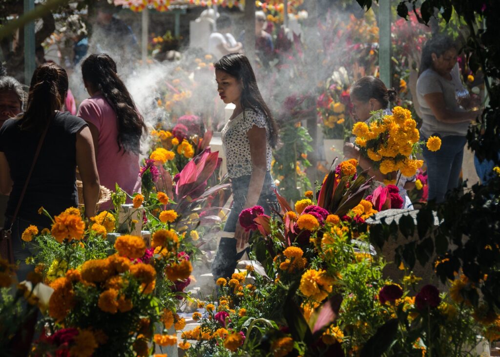 A woman walks through various offrendas in Mexico.