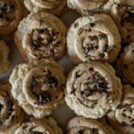 A stack of peppermint crisp sugar cookies with pieces of chocolate on top.