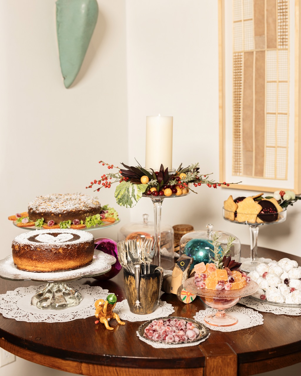 A brown table is full of various desserts like three cakes and pieces of apricot candy.