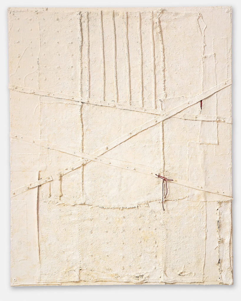 An abstract, textured painting or mixed media work. It features a heavily layered, off-white surface with visible drips, scratches, and other textural elements.