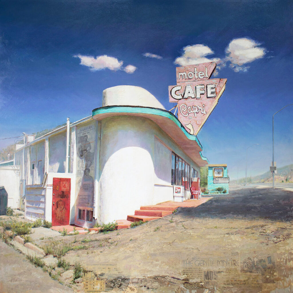 An old, vintage-style motel and cafe building set against a bright blue sky with fluffy white clouds.