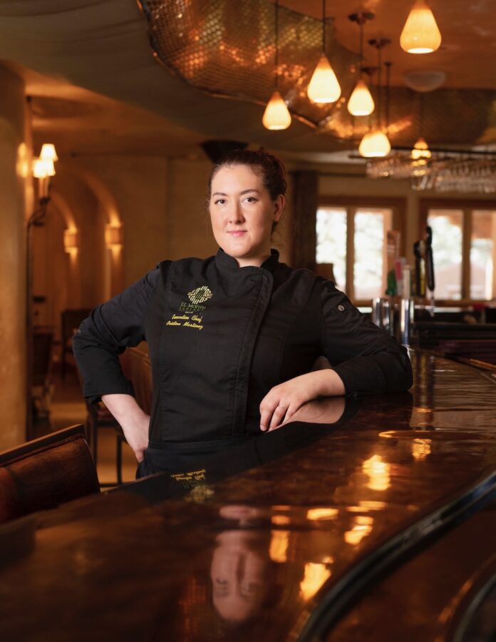 Cristina Martinez. Chef, El Monte Segardao. Taos NM, stands at a dimly lit bar