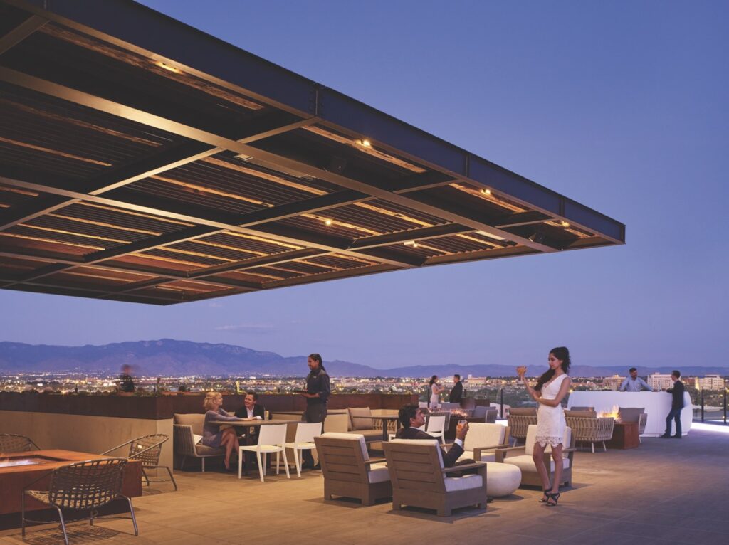 An outdoor dining space at Heritage Hotels with a flat roof over it that overlooks the mountains.