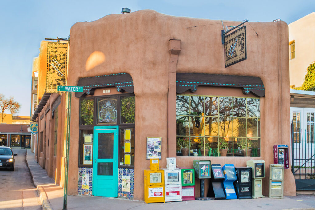 Cafe Pasqual's, a beloved Santa Fe institution, housed in an adobe-style building with a turquoise door.