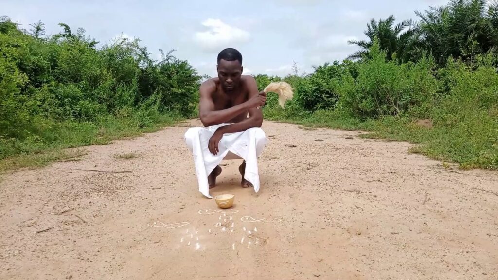 A man crouches on a dirt road as a part of a film still for Experiments in Cinema Festival.