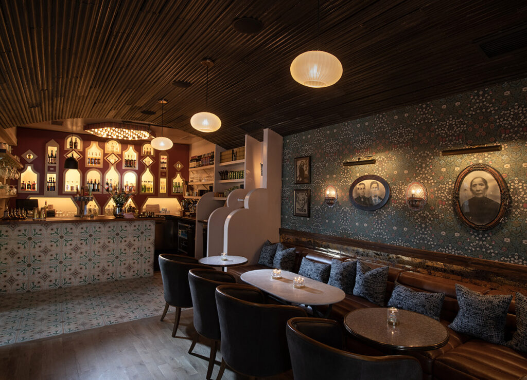 Santa Fe's Bar Norte interior featuring a stylish bar, vintage decor, and cozy seating with warm ambient lighting.