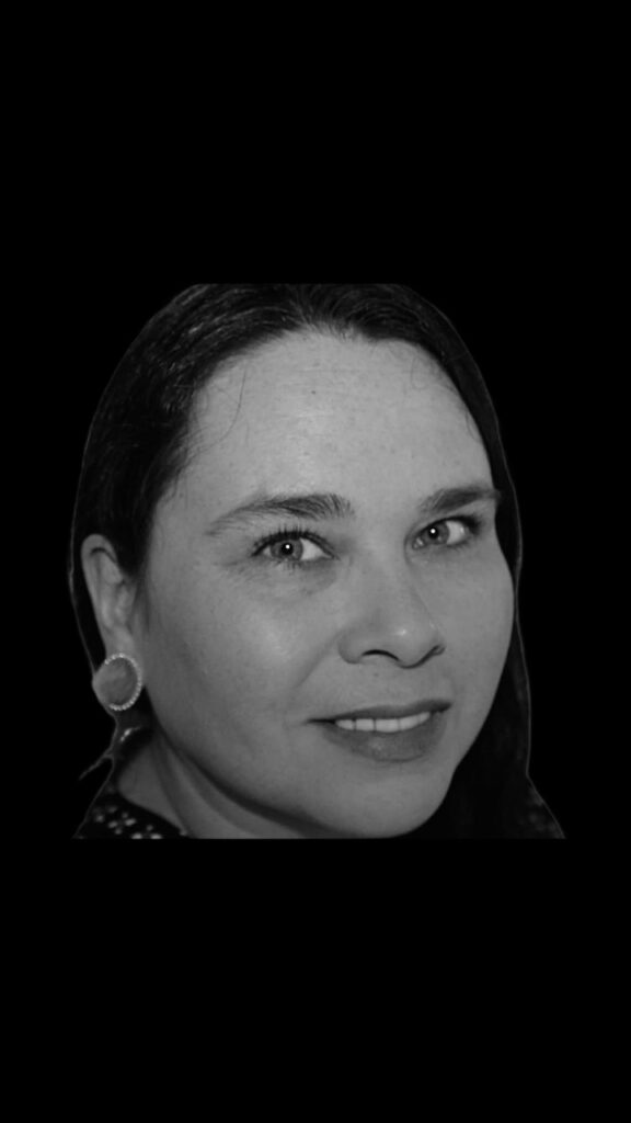 A portrait of a woman with her hair in a bun in black adn white.