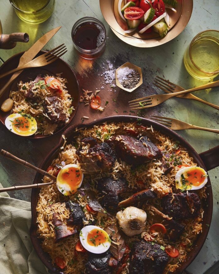 Beef Short Rib Plov for Navrus A beef short rib plov for navrus sits in a big dish with rice, beef short rib, and boiled eggs cut in half.