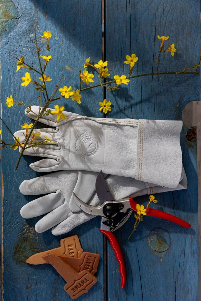 A pair of light-colored Womanswork gardening gloves.