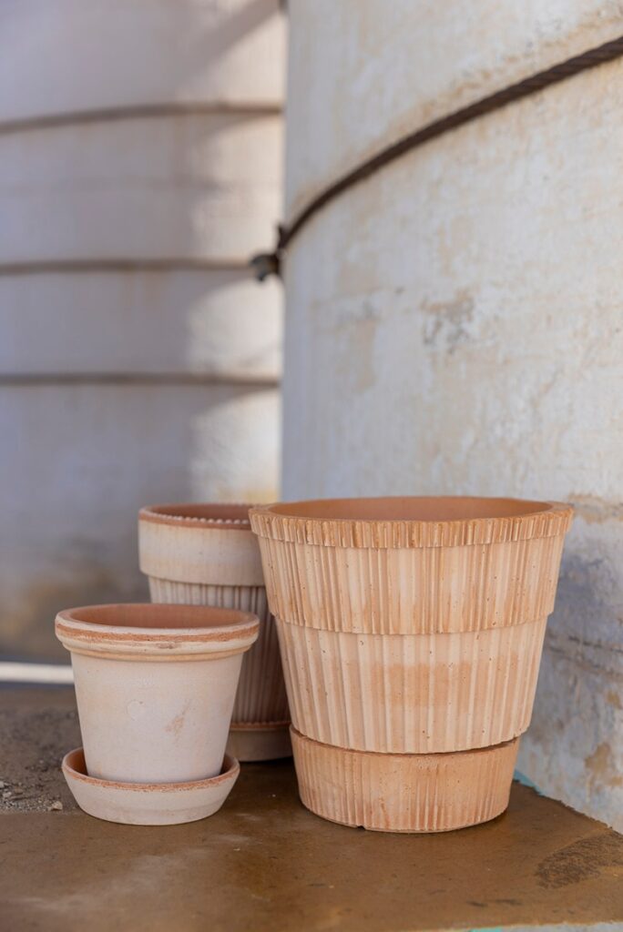 Three handcrafted raw clay pots, possibly Bergs Atlas Planters, of varying sizes with ridged textures.