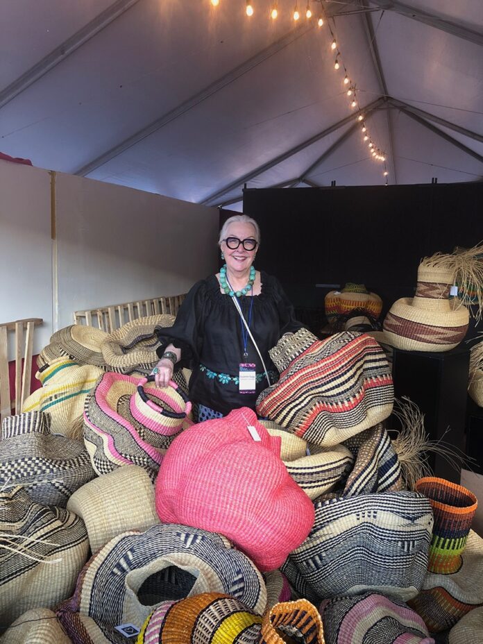 International Folk Art Market scene with a diverse crowd of people Browse various artisan stalls under clear skies, featuring colorful textiles, pottery, and other handcrafted goods.