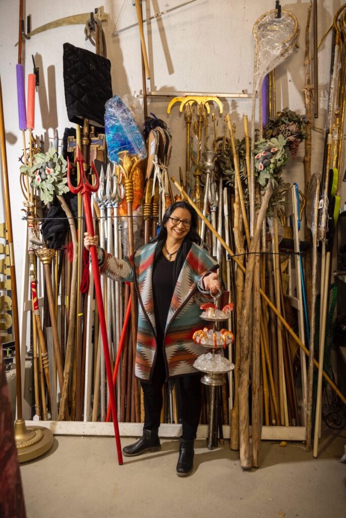 A prop master at the Santa Fe Opera stands in front of a wall of prop sticks.