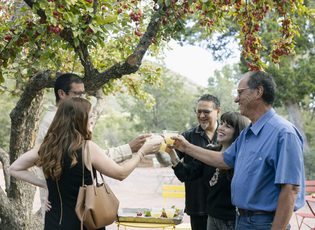 A group of people joyfully toasting with wine glasses, celebrating a special occasion together.