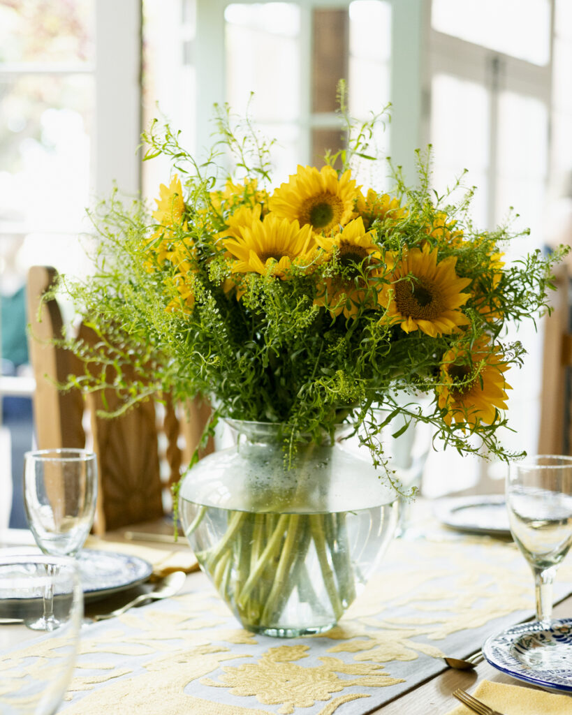 A vase filled with vibrant yellow flowers, symbolizing beauty and joy, sits on a table.