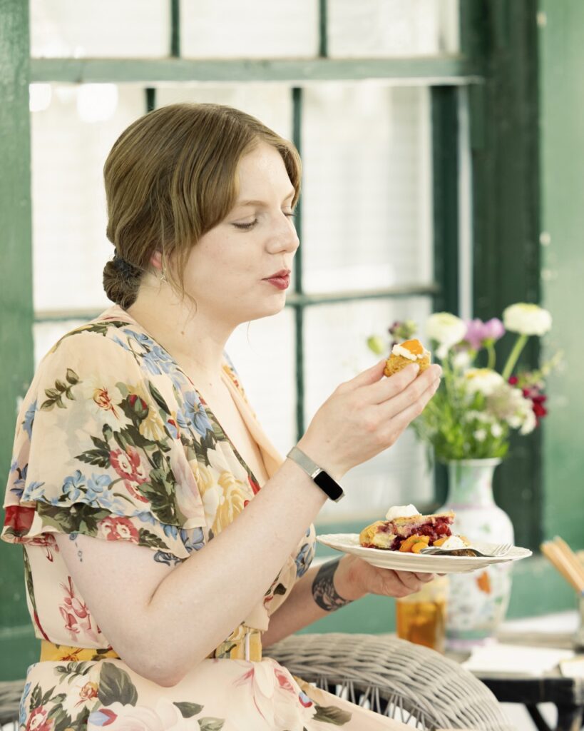 A woman bites into a piece of cherry pie at the El Zaguan stone fruit tea party.