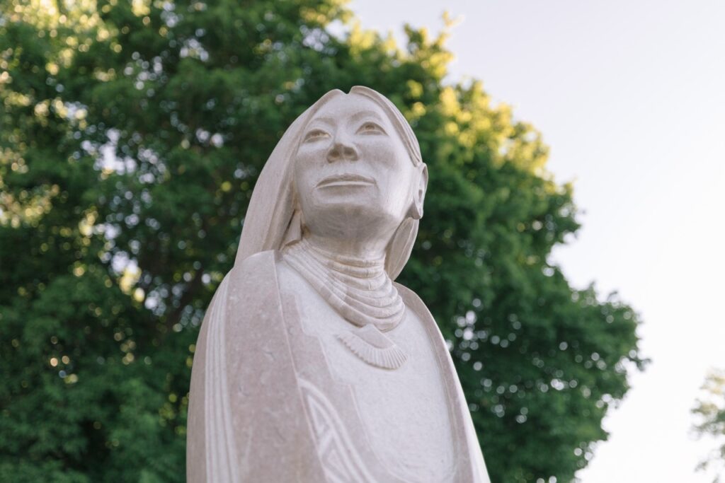 Close-up stone bust of a woman looking upwards.