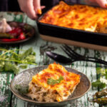 Green Chile Chicken Enchilada Casserole served in a plate which is placed on a wooden surface