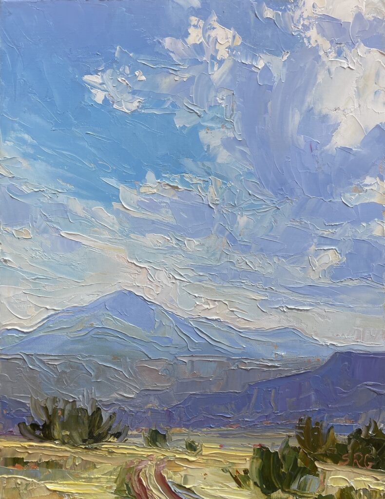 A painting of mountains and skies in New Mexico at Cafe Pasqual's Gallery.