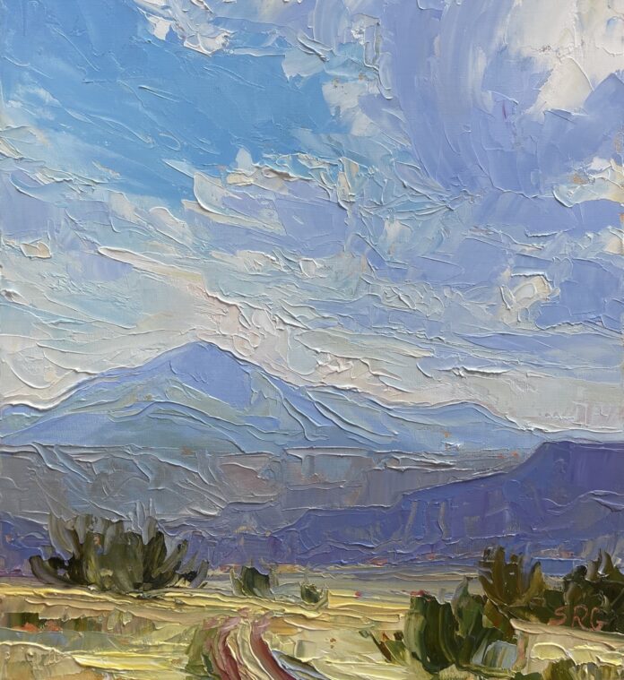 A painting of mountains and skies in New Mexico at Cafe Pasqual's Gallery.