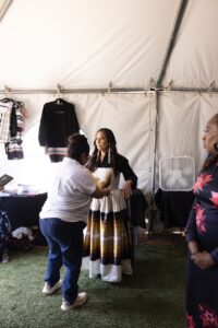 Native Fashion Week 2025 16 TABLE Magazine A woman adjusts another woman's dress.