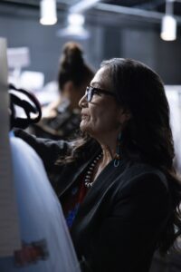 Native Fashion Week 2025 2 TABLE Magazine A woman browses through a rack of clothes.