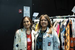 Native Fashion Week 2025 8 TABLE Magazine A woman in a white jacket stands with a woman in a jean jacket.