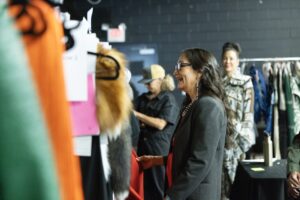 Native Fashion Week 2025 TABLE Magazine A woman looks through a rack of clothes.