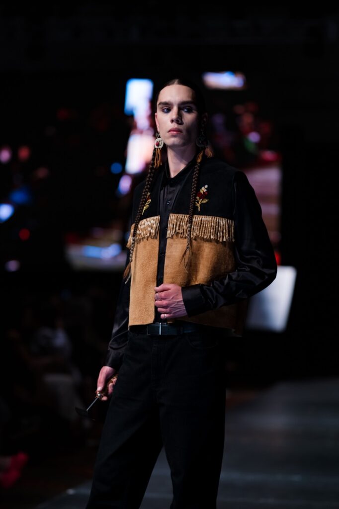 SWAIA Native Fashion Week 12 TABLE Magazine A woman with braids poses in a native esc hoodie.