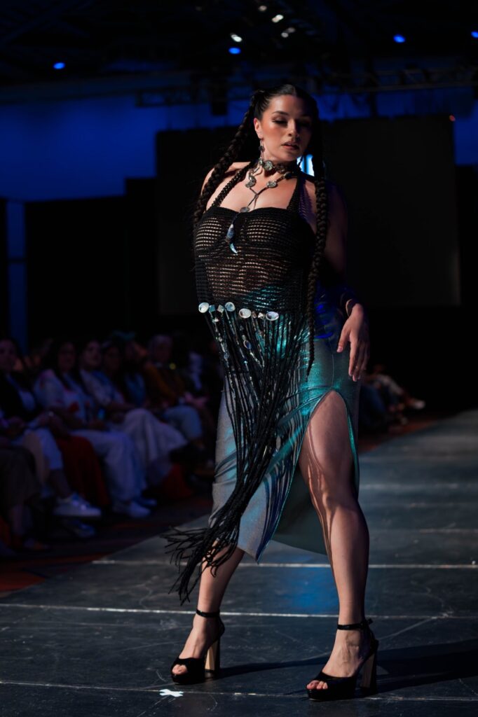 SWAIA Native Fashion Week 14 TABLE Magazine A woman in a black net and iridescent blue dress.