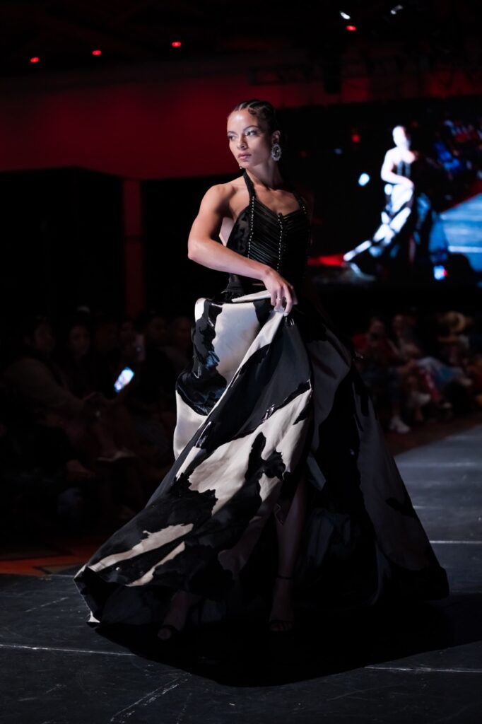 SWAIA Native Fashion Week 2 TABLE Magazine A woman in a white and black dress poses on stage.