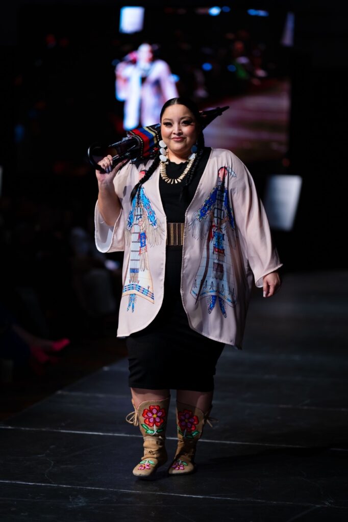 SWAIA Native Fashion Week 5 TABLE Magazine A woman with an umbrella closed over her shoulder down the runway.